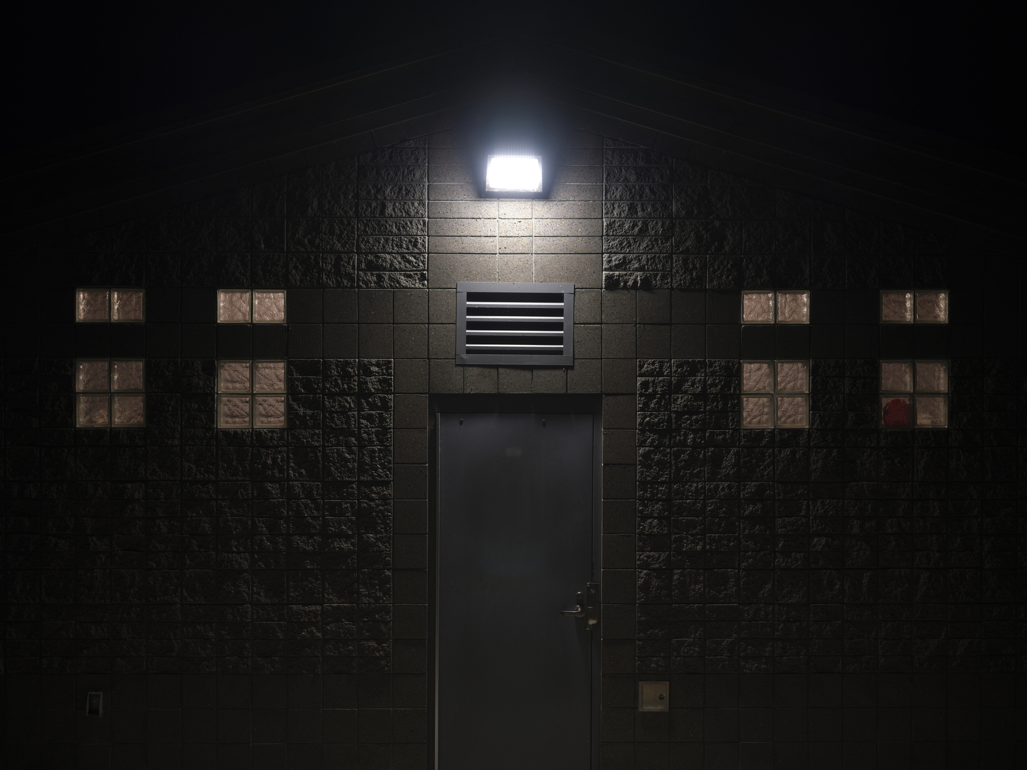 Floodlight illuminating outside of a structure at night, Lighting Techniques.